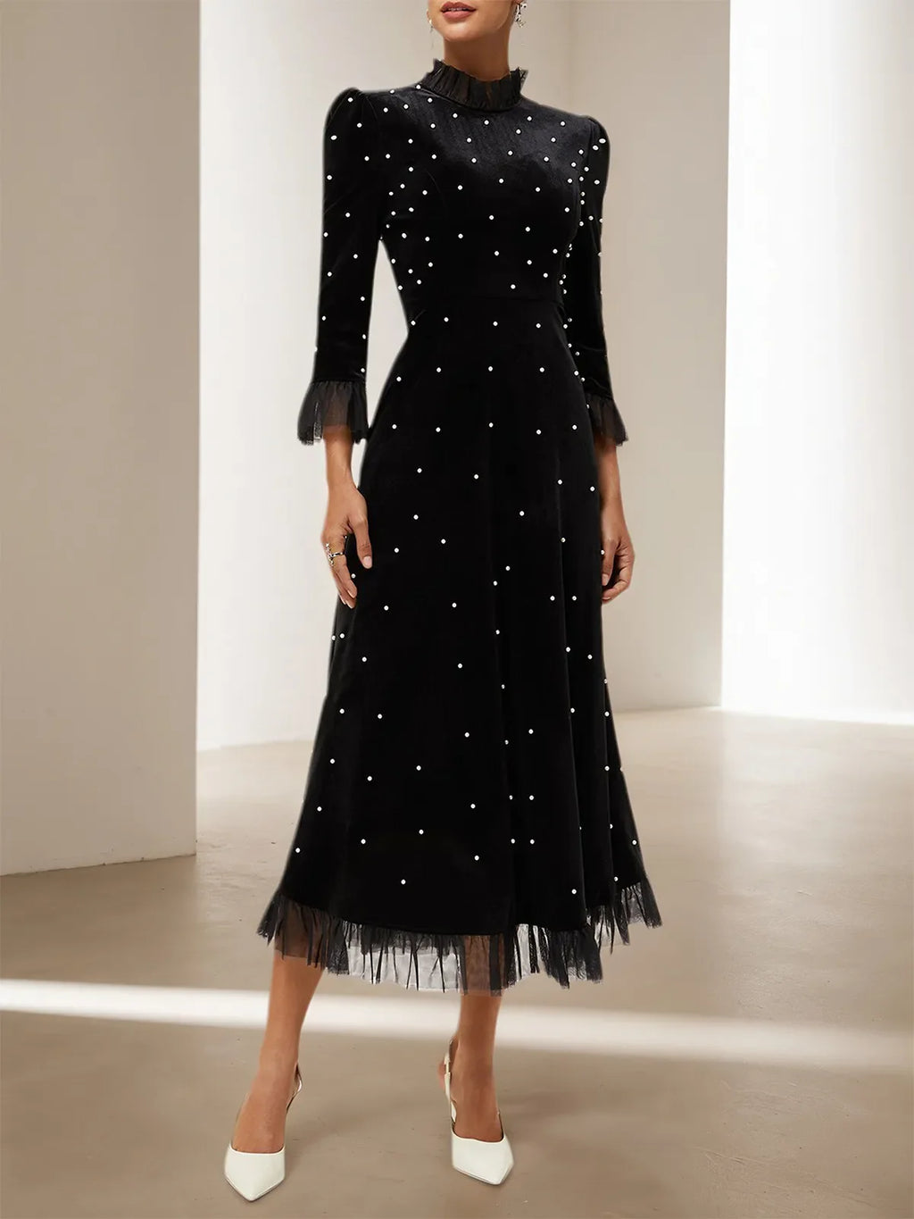 Vestido largo de terciopelo negro línea A con cuello alto de cuentas y mangas tres cuartos