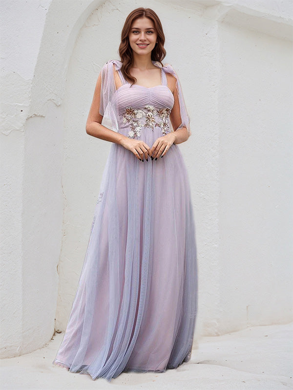 Vestido de madrinha rosa em tule, corte A, alças finas, sem mangas, comprimento até o chão, com aplicação