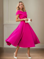 Vestido curto de mãe da noiva em crepe stretch fúcsia, linha A, ombro a ombro e mangas curtas, comprimento chá