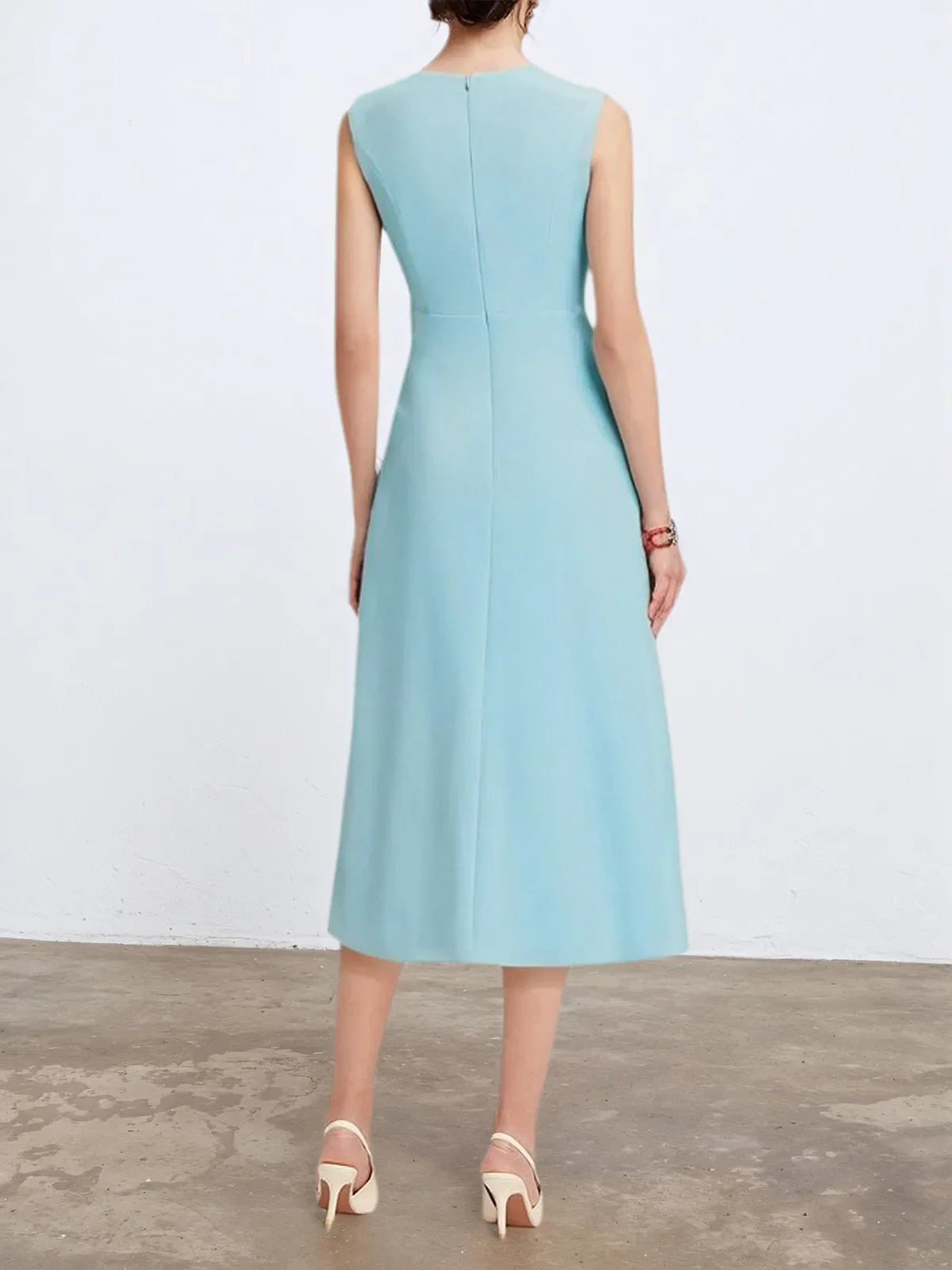 Vestido midi elegante azul claro, sem mangas, corte evasê, com torção na cintura para usar do dia à noite