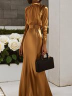 Vestido largo de satén dorado con fruncido, cuello alto y mangas largas en línea A