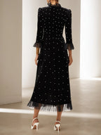 Vestido largo de terciopelo negro línea A con cuello alto de cuentas y mangas tres cuartos