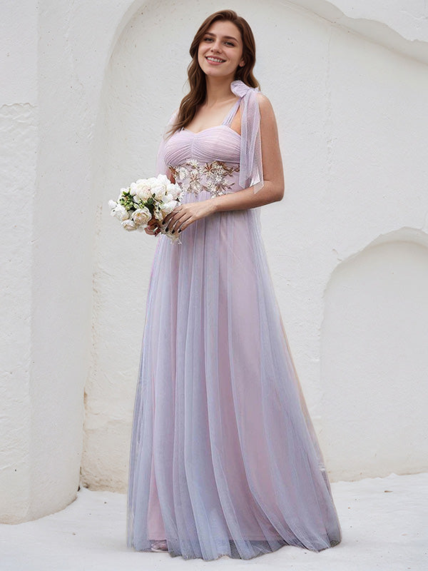 Vestido de madrinha rosa em tule, corte A, alças finas, sem mangas, comprimento até o chão, com aplicação