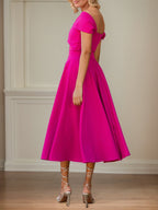 Vestido curto de mãe da noiva em crepe stretch fúcsia, linha A, ombro a ombro e mangas curtas, comprimento chá