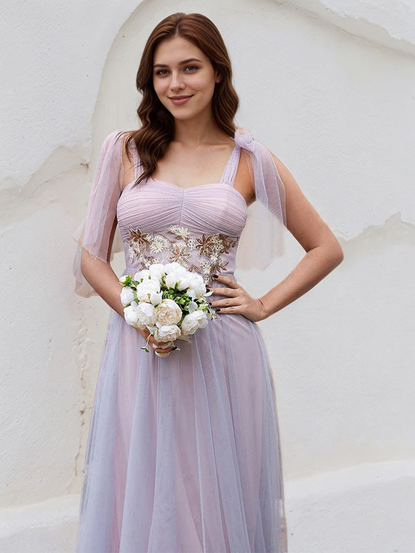 Vestido de madrinha rosa em tule, corte A, alças finas, sem mangas, comprimento até o chão, com aplicação
