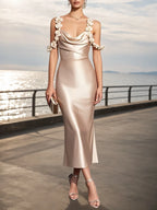 Vestido midi de satén color champán con flores 3D, cuello drapeado y sin mangas tipo columna