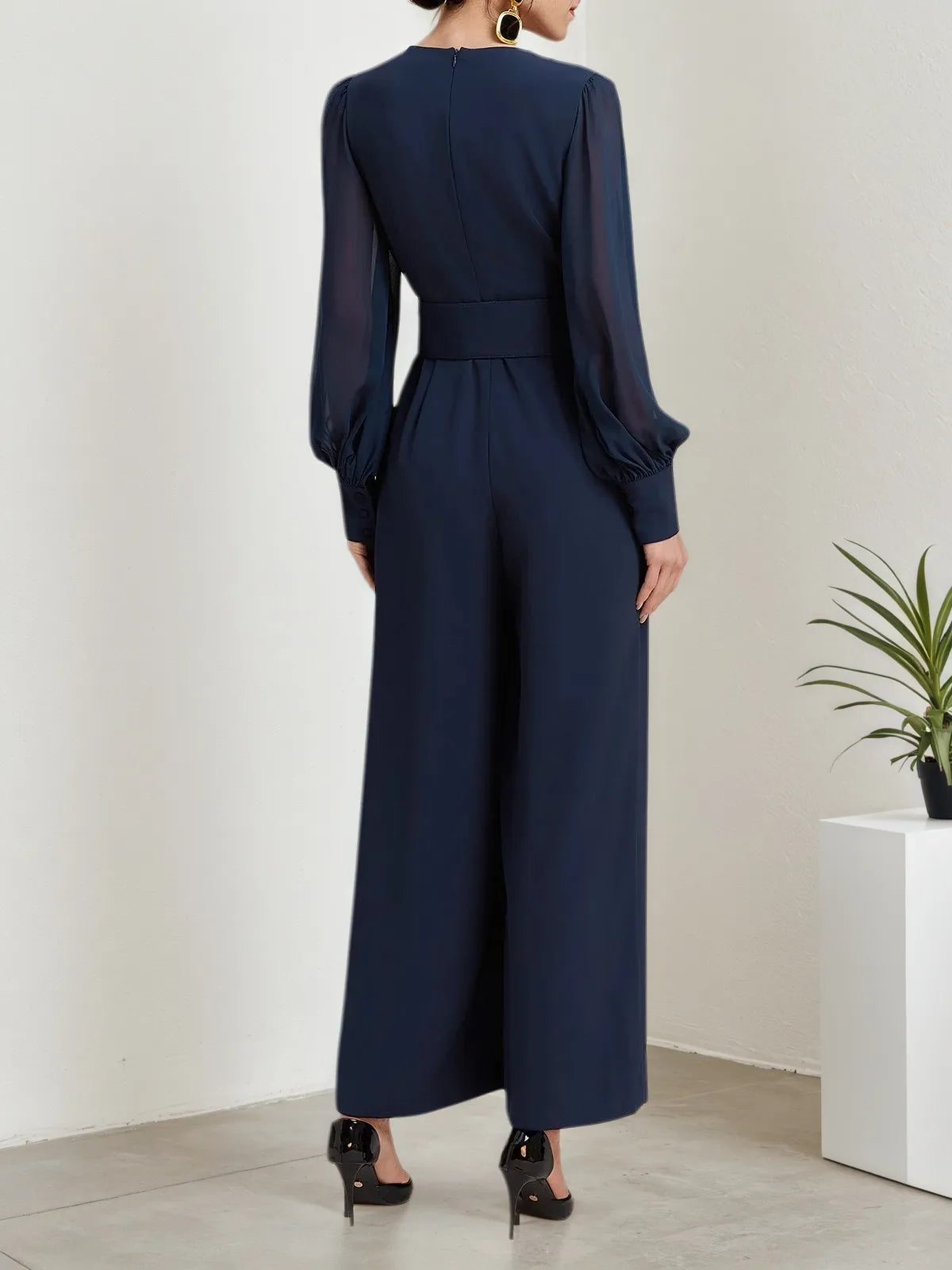 Macacão azul escuro de chiffon com gola em V, mangas bufantes e pernas largas