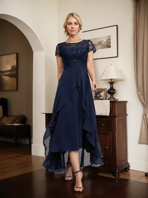 Vestido de mãe da noiva em chiffon assimétrico com decote redondo, ilusão, renda, laço, babados e lantejoulas em corte evasê
