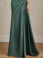 Vestido formal verde con un solo hombro, cinturón de pedrería en la cintura y largo hasta el suelo