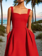 Vestido midi vermelho corte A, sem mangas, decote coração clássico, com bolsos e costura decorativa