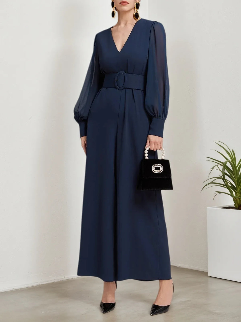 Macacão azul escuro de chiffon com gola em V, mangas bufantes e pernas largas