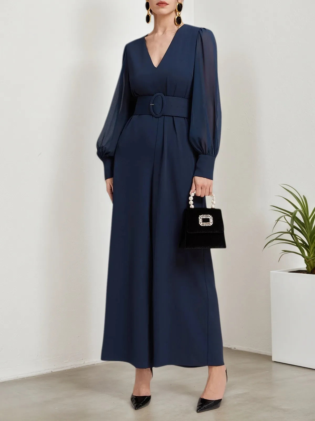 Macacão azul escuro de chiffon com gola em V, mangas bufantes e pernas largas