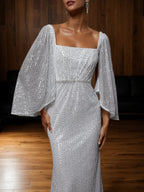 Vestido tubo plateado con lentejuelas de pedrería, escote cuadrado y mangas tres cuartos