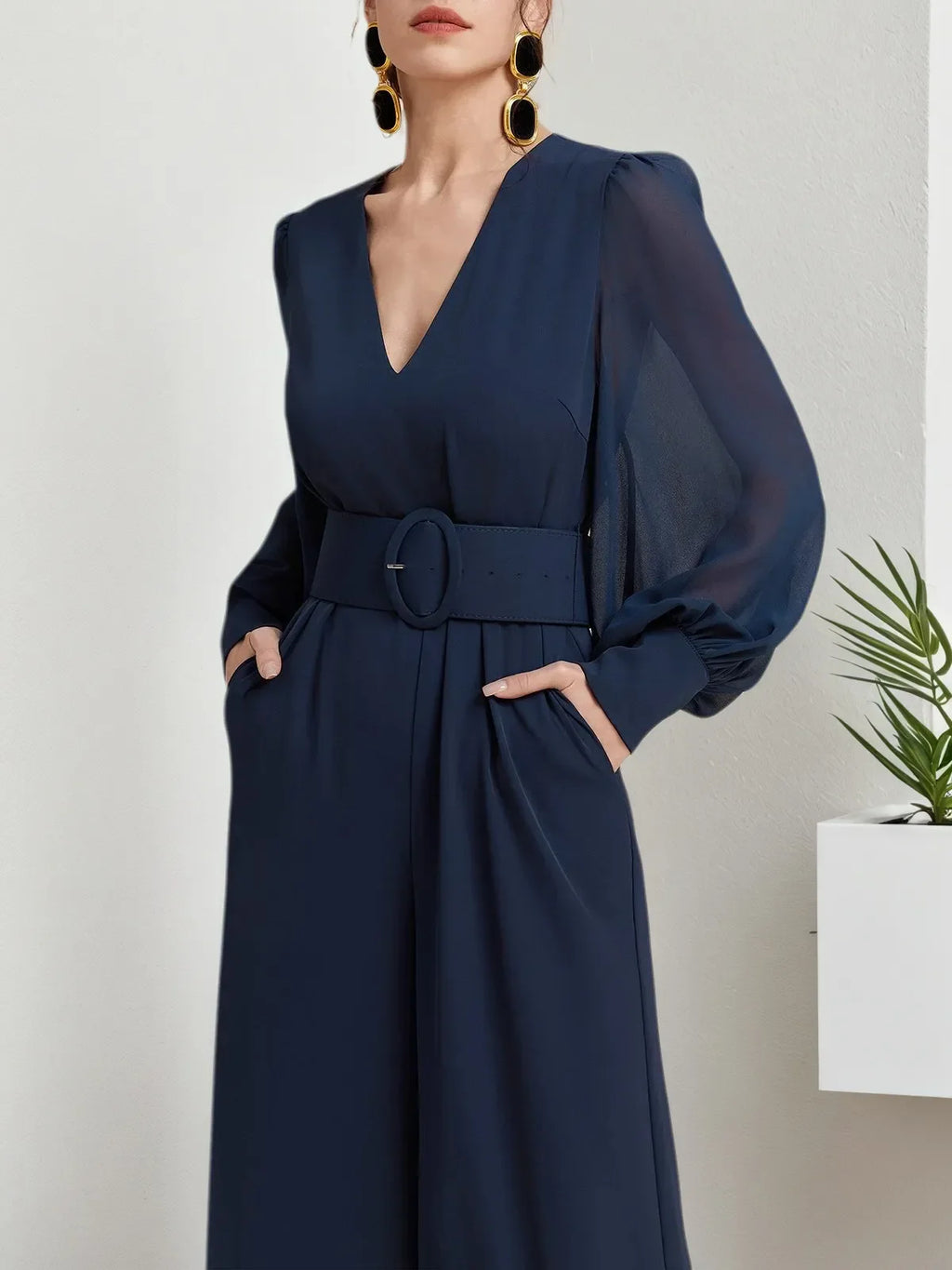 Macacão azul escuro de chiffon com gola em V, mangas bufantes e pernas largas