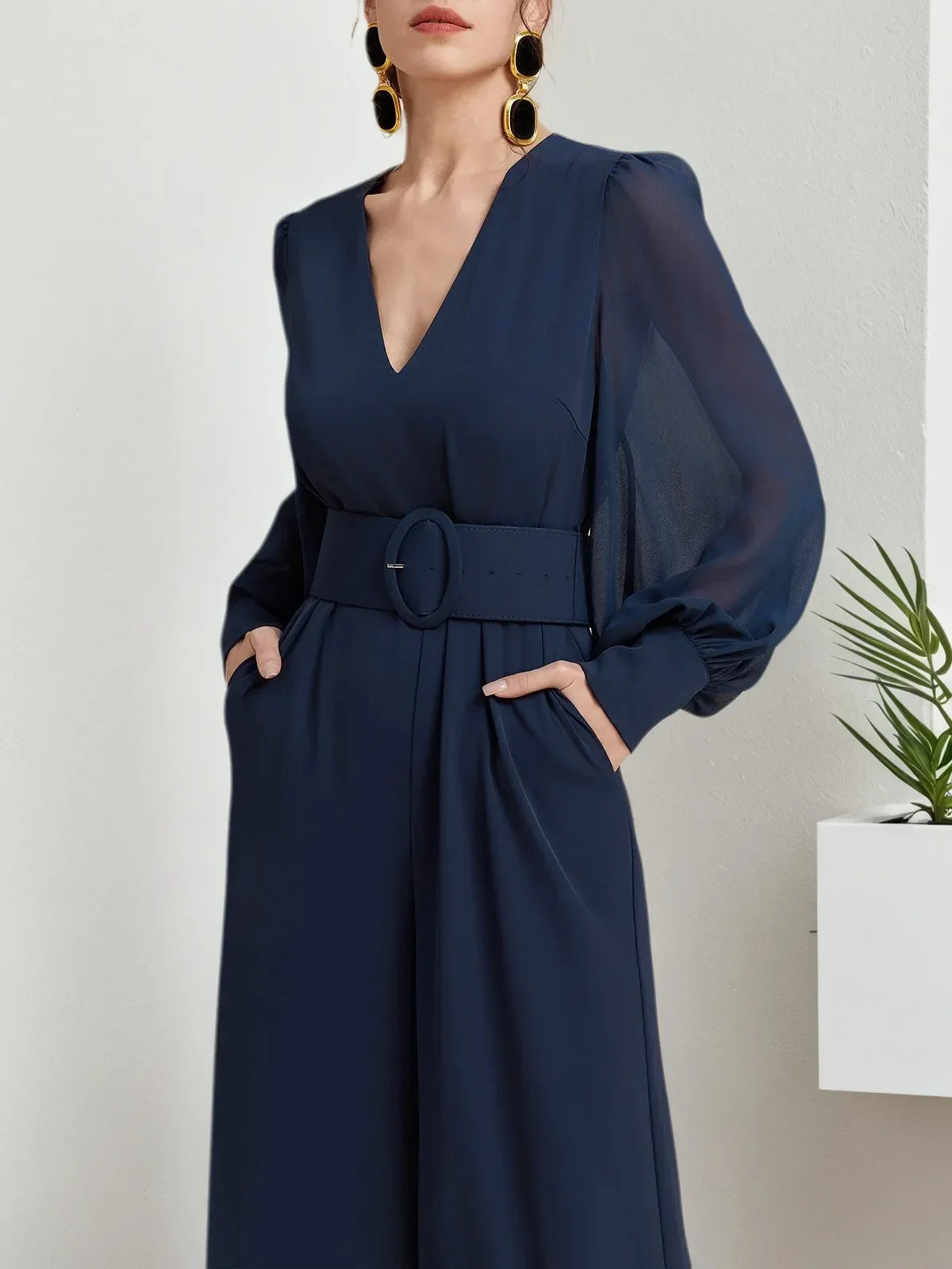 Macacão azul escuro de chiffon com gola em V, mangas bufantes e pernas largas