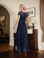 Vestido de mãe da noiva em chiffon assimétrico com decote redondo, ilusão, renda, laço, babados e lantejoulas em corte evasê