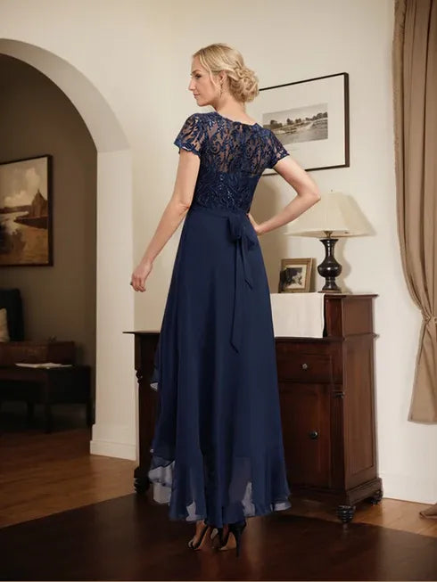 Vestido de mãe da noiva em chiffon assimétrico com decote redondo, ilusão, renda, laço, babados e lantejoulas em corte evasê