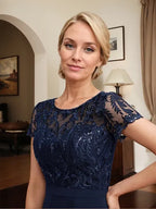 Vestido de mãe da noiva em chiffon assimétrico com decote redondo, ilusão, renda, laço, babados e lantejoulas em corte evasê