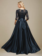 Vestido de mãe da noiva em cetim stretch com renda, comprimento até o chão, corte evasê, decote redondo com ilusão e laço com paetês