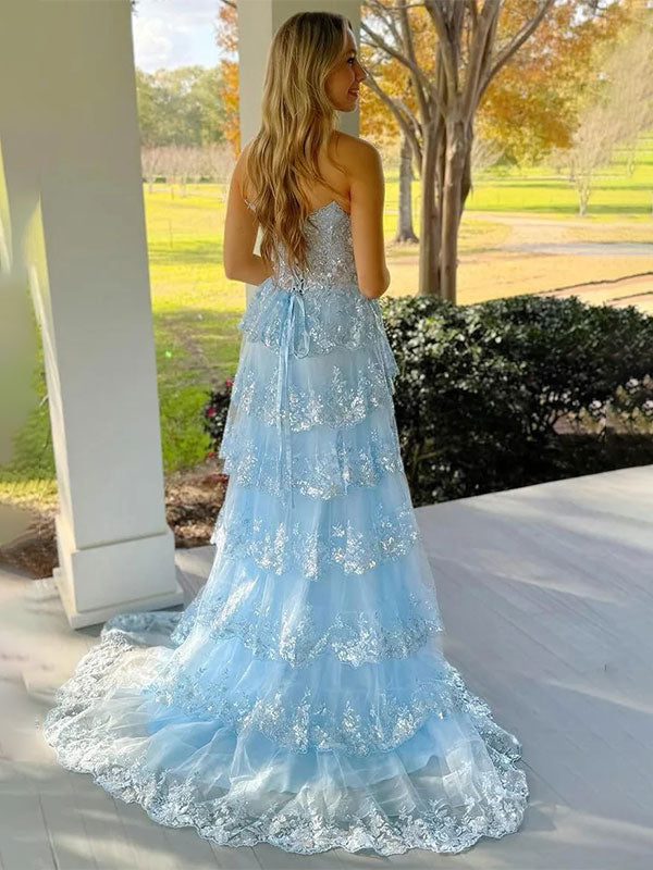 Vestido de fiesta azul línea A sin tirantes con escote en V, apliques y volantes con abertura