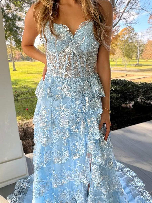Vestido de fiesta azul línea A sin tirantes con escote en V, apliques y volantes con abertura