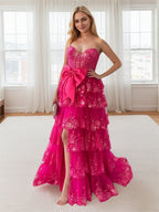 Abito da ballo rosa acceso con balze a strati, paillettes, fiocco decorativo e spacco
