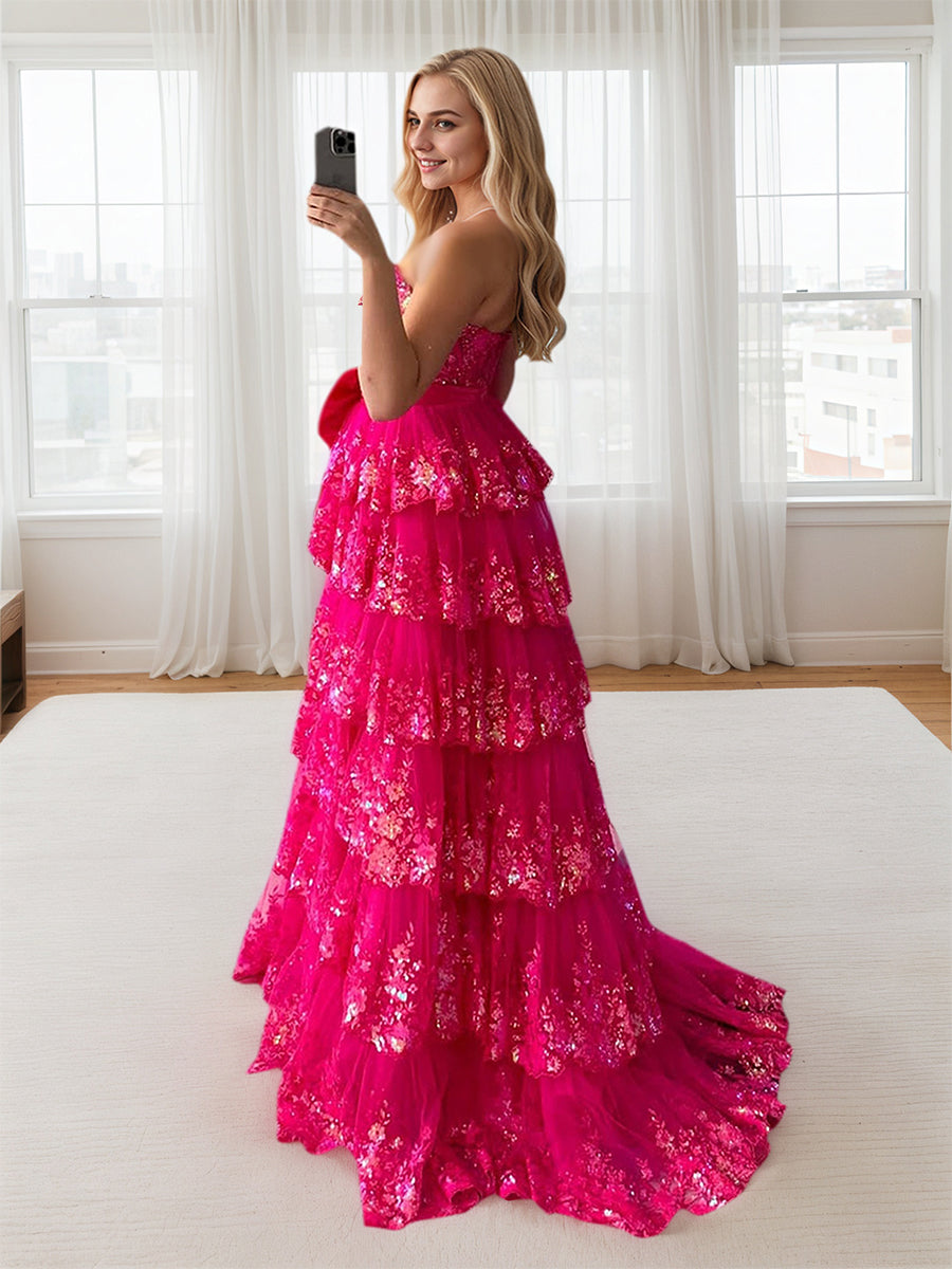 Abito da ballo rosa acceso con balze a strati, paillettes, fiocco decorativo e spacco