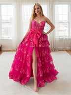 Abito da ballo rosa acceso con balze a strati, paillettes, fiocco decorativo e spacco