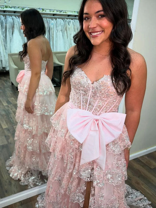 Abito da ballo rosa acceso con balze a strati, paillettes, fiocco decorativo e spacco