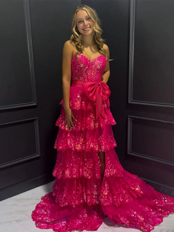 Abito da ballo rosa acceso con balze a strati, paillettes, fiocco decorativo e spacco