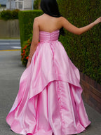 Vestido de fiesta rosa satinado sin tirantes con cuerpo fruncido y falda asimétrica en capas