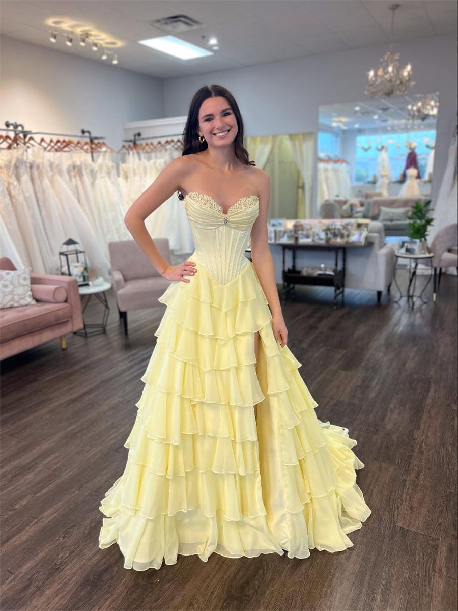 Vestido de baile amarelo tomara que caia com corpete, babados em camadas e fenda alta
