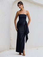 Vestido preto de cetim ombro a ombro, sem mangas, com babados e fenda alta