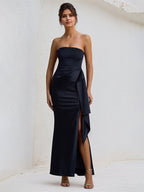 Vestido preto de cetim ombro a ombro, sem mangas, com babados e fenda alta
