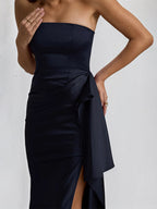 Vestido preto de cetim ombro a ombro, sem mangas, com babados e fenda alta